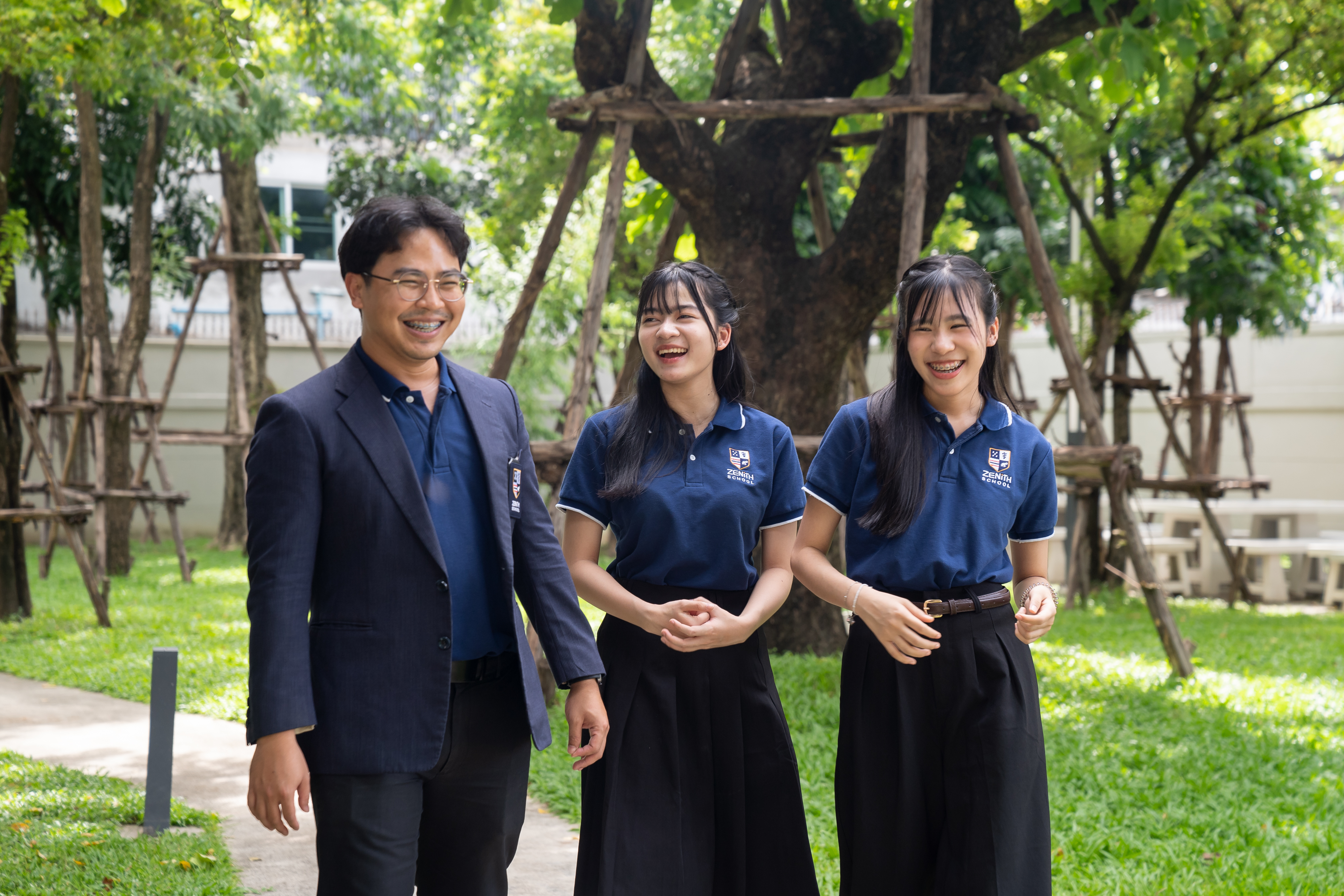 A teacher and student walking and talking in the school garden at Zenith School